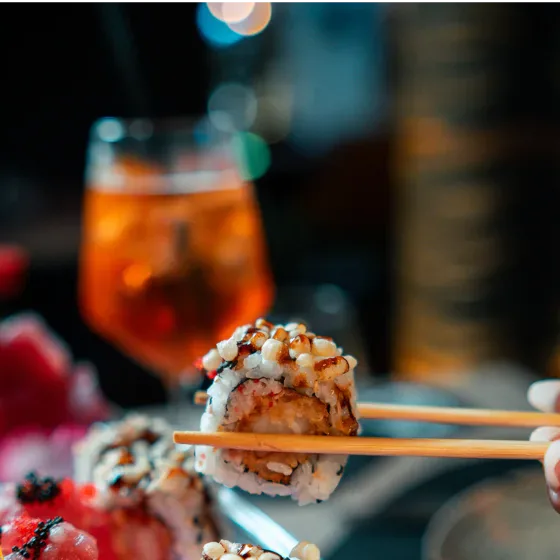 Sushi mit Stäbchen und ein Spritz