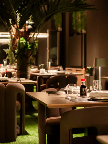 Dining room with plants and tables set for dinner